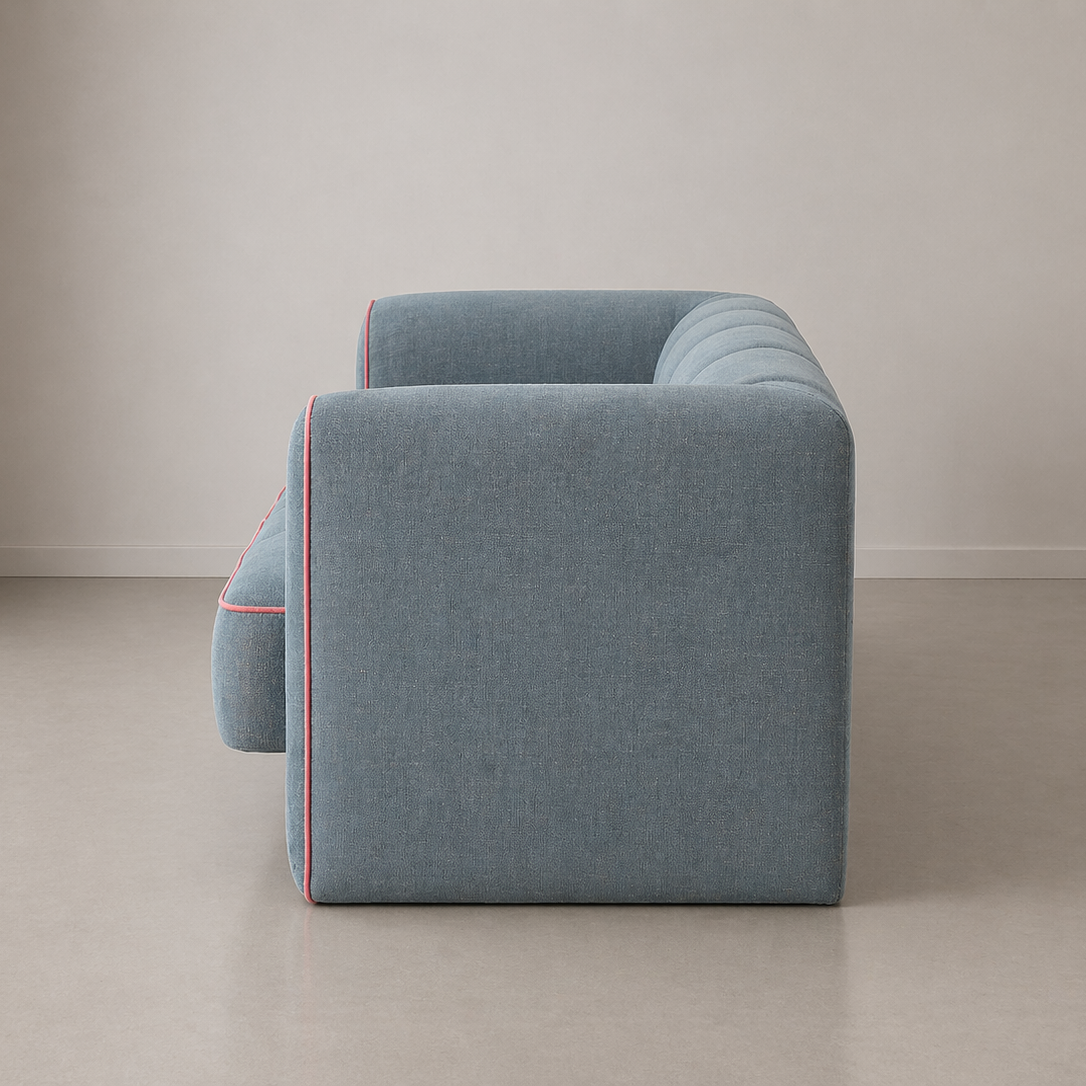 Blue sofa with red piping on a plain background