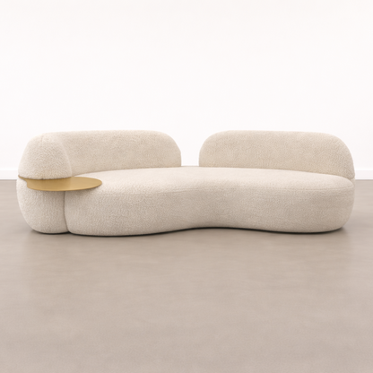 Modern beige sofa with a gold armrest on a neutral background